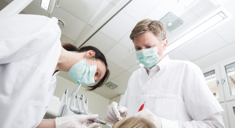 Dentist performing tooth extraction in Winnipeg